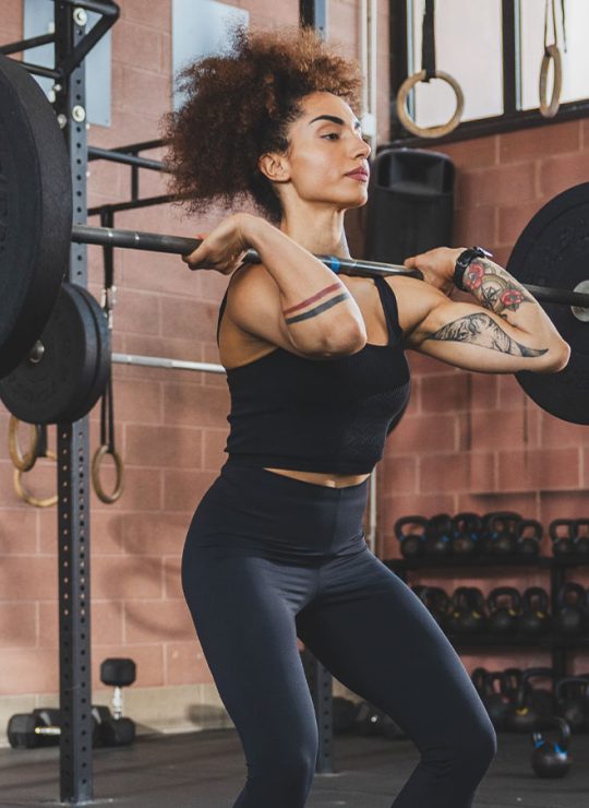 Atleta di cross-fit durante un esecizio con il bilanciere