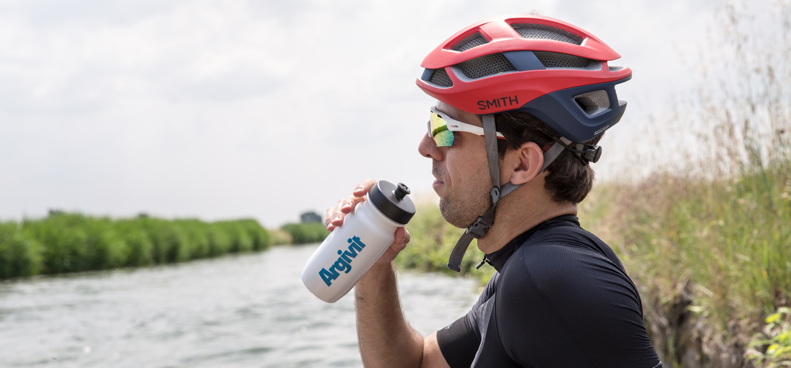 Ciclista che si reidrata bevendo Argivt